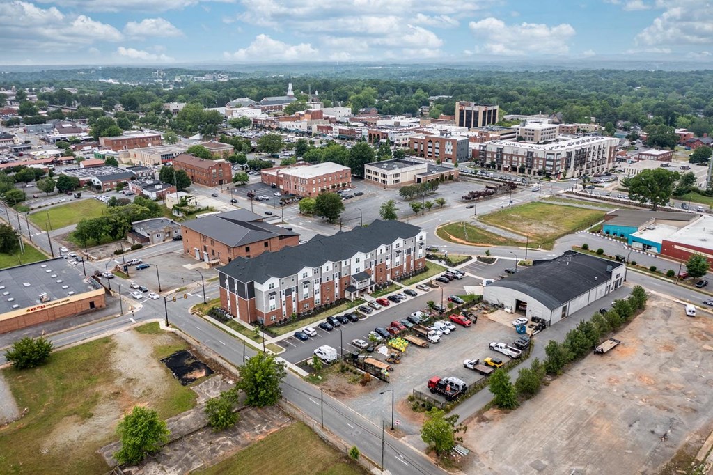 an aerial view of a city with a parking lot and buildings