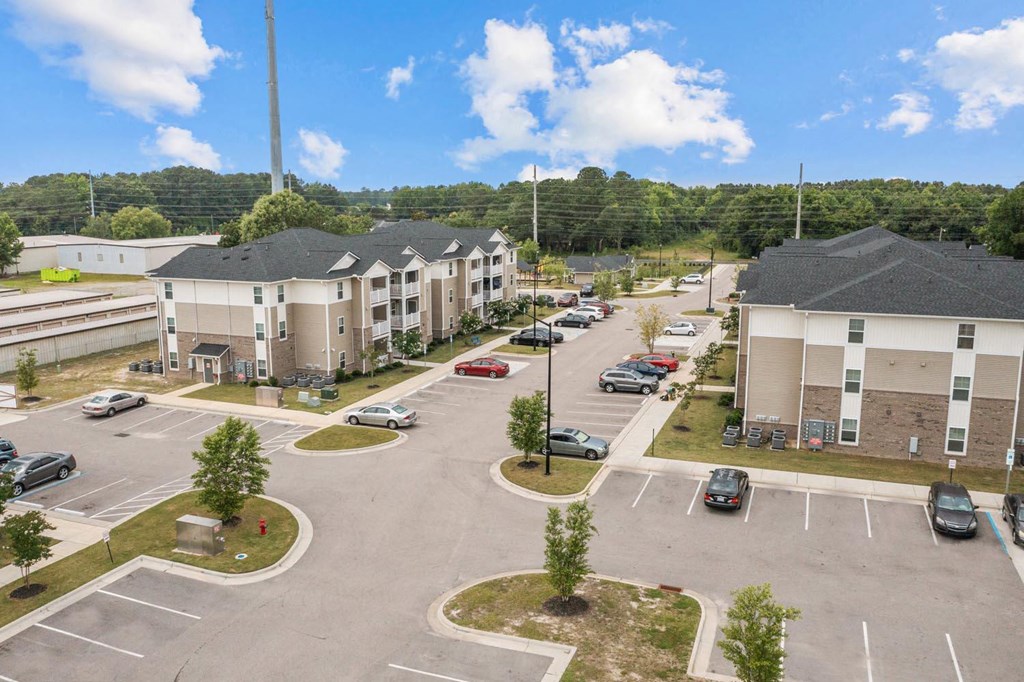 an aerial view of an apartment complex with cars in a parking lot