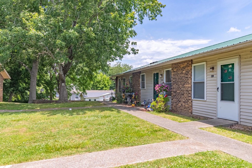 a brick building with a white door and green shutters