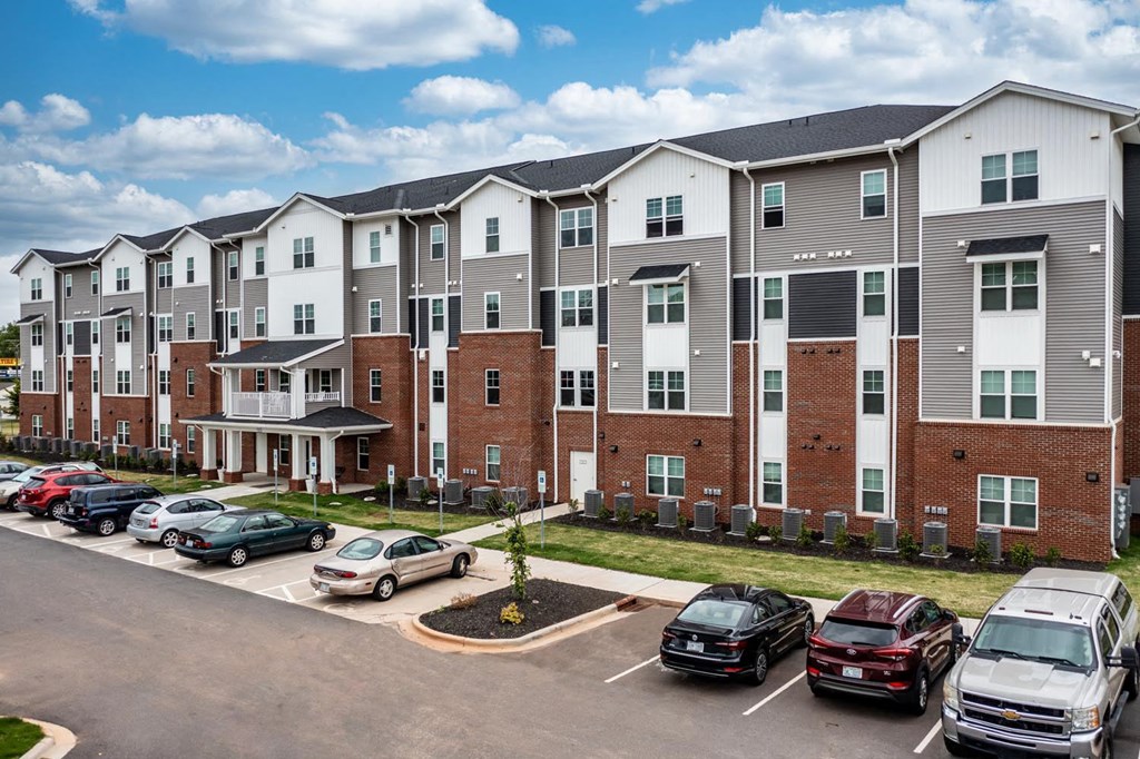 a large apartment complex with cars parked in front of it
