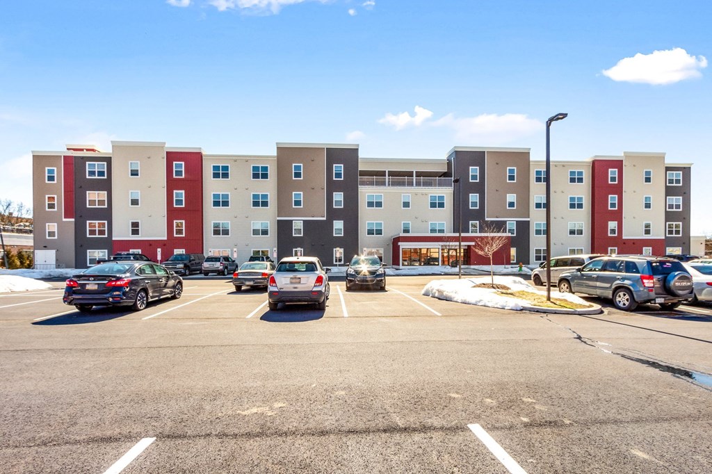 a parking lot with cars in front of an apartment building