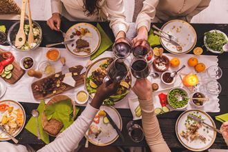 a group of people drinking wine over a table full of food