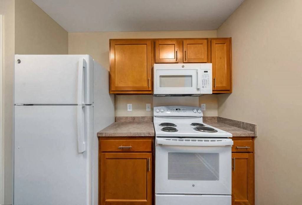 a kitchen with white appliances and wooden cabinets