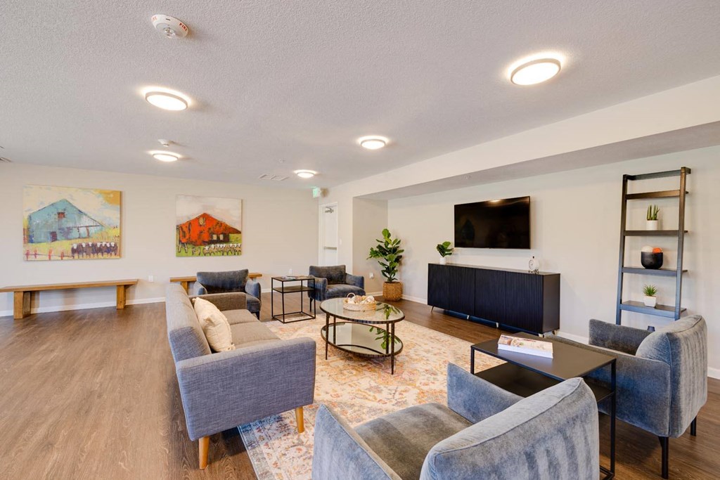 a living room with couches and chairs and a tv on the wall