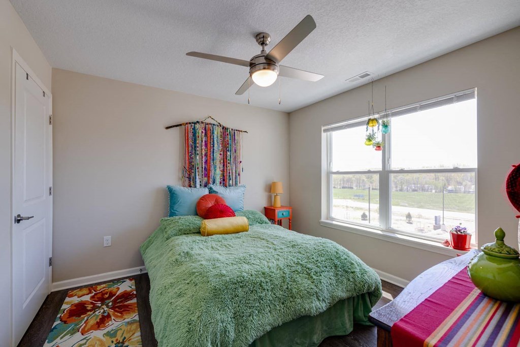 a bedroom with a bed and a ceiling fan