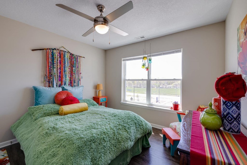 a bedroom with a bed and a ceiling fan