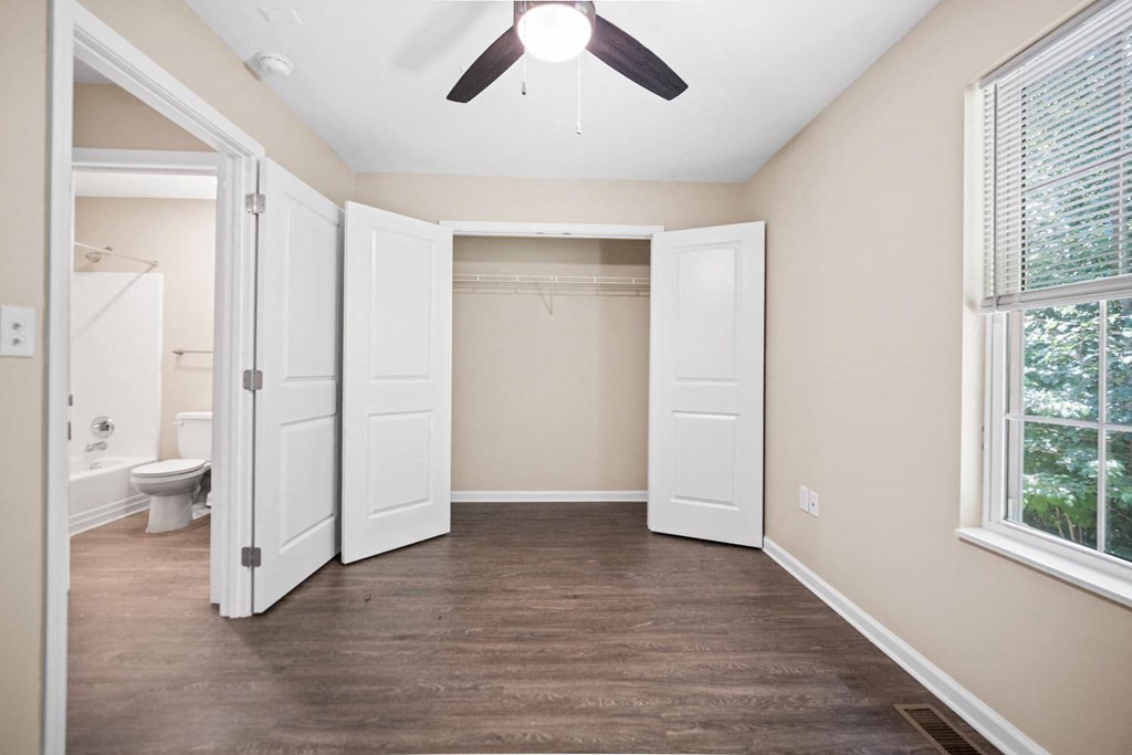 a bedroom with a ceiling fan and a closet
