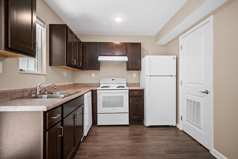 a kitchen with a stove refrigerator and sink