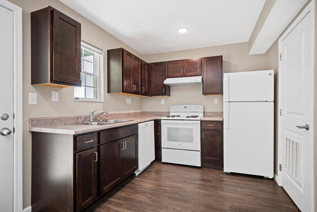 a kitchen with dark cabinets and a white refrigerator