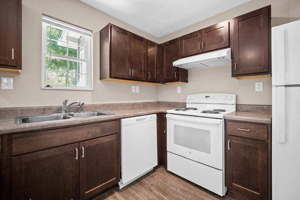 a kitchen with white appliances and dark wood cabinets