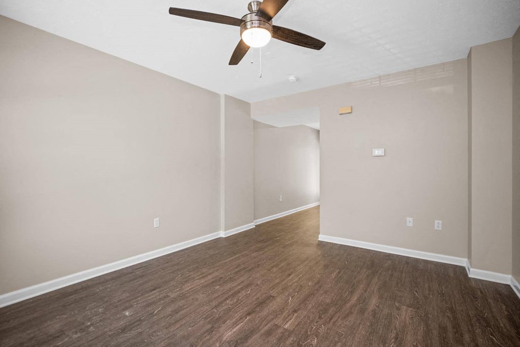 a living room with wood floors and a ceiling fan