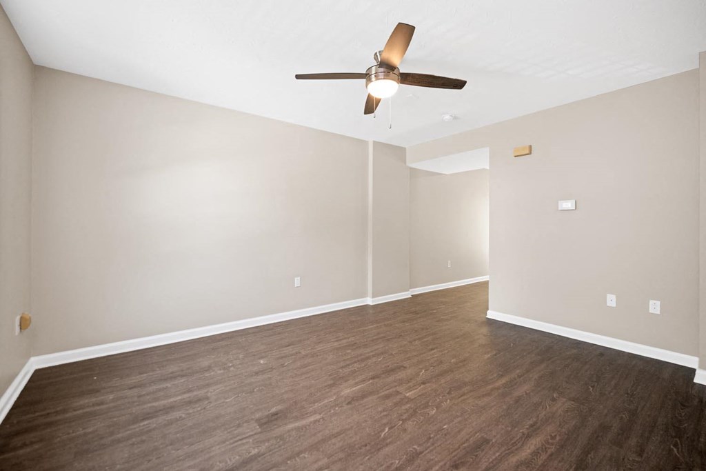 a living room with wood floors and a ceiling fan