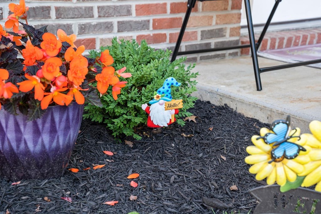 a garden with flowers and a small gnome in the dirt