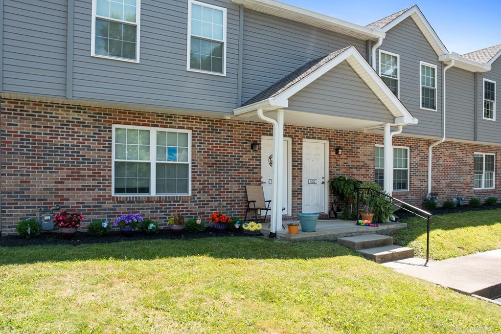the front of a house with steps and a lawn