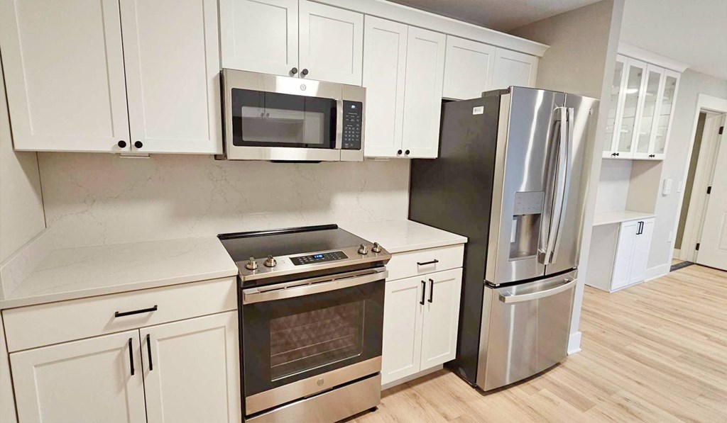 a kitchen with stainless steel appliances and white cabinets