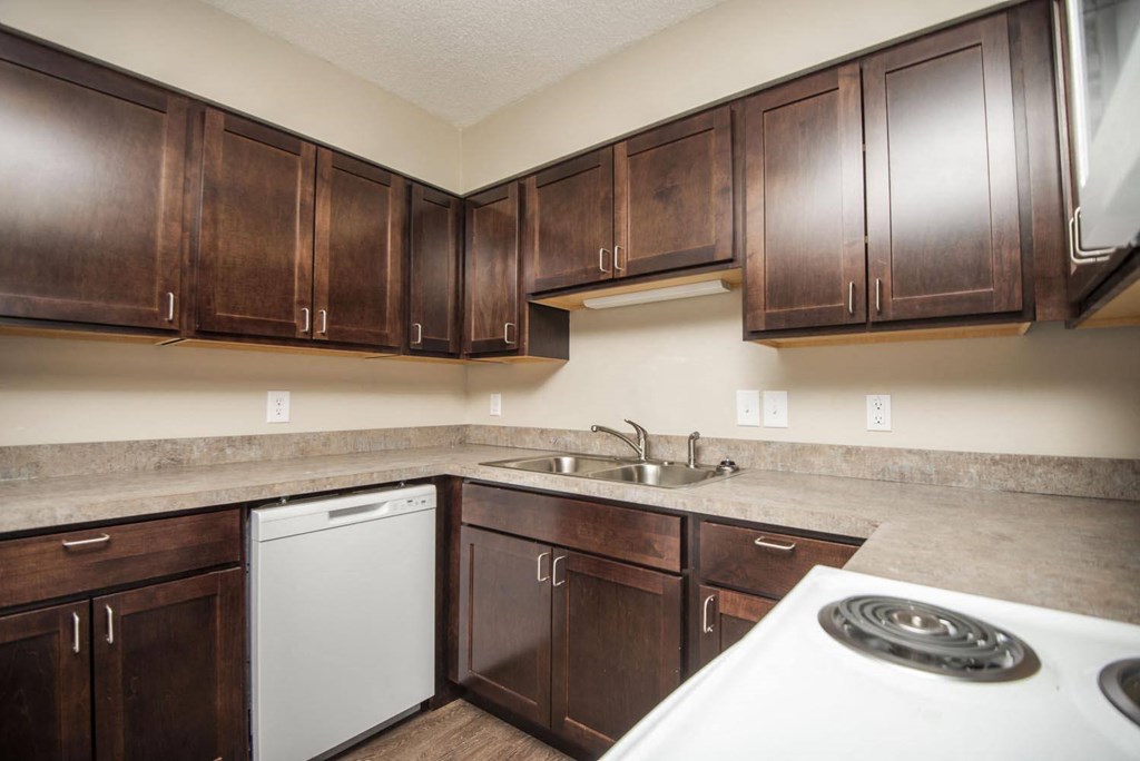a kitchen with dark wood cabinets and white appliances