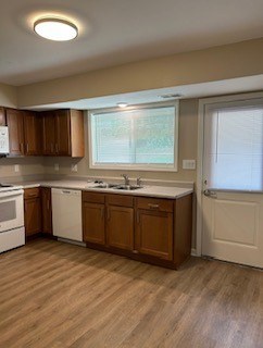 A kitchen with wooden cabinets and a white dishwasher.