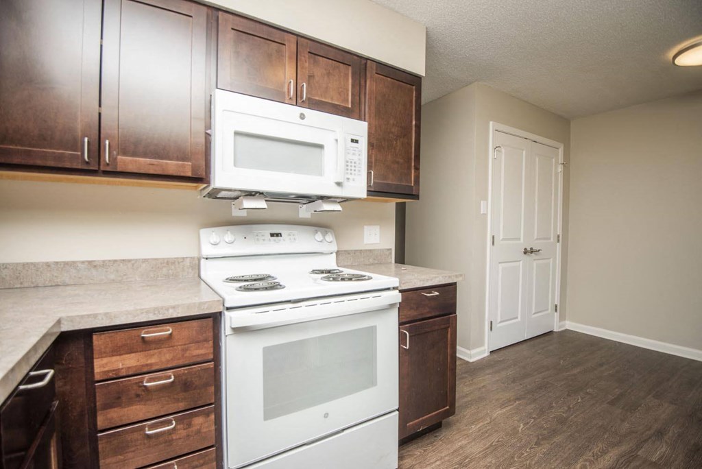 a kitchen with white appliances and wooden cabinets
