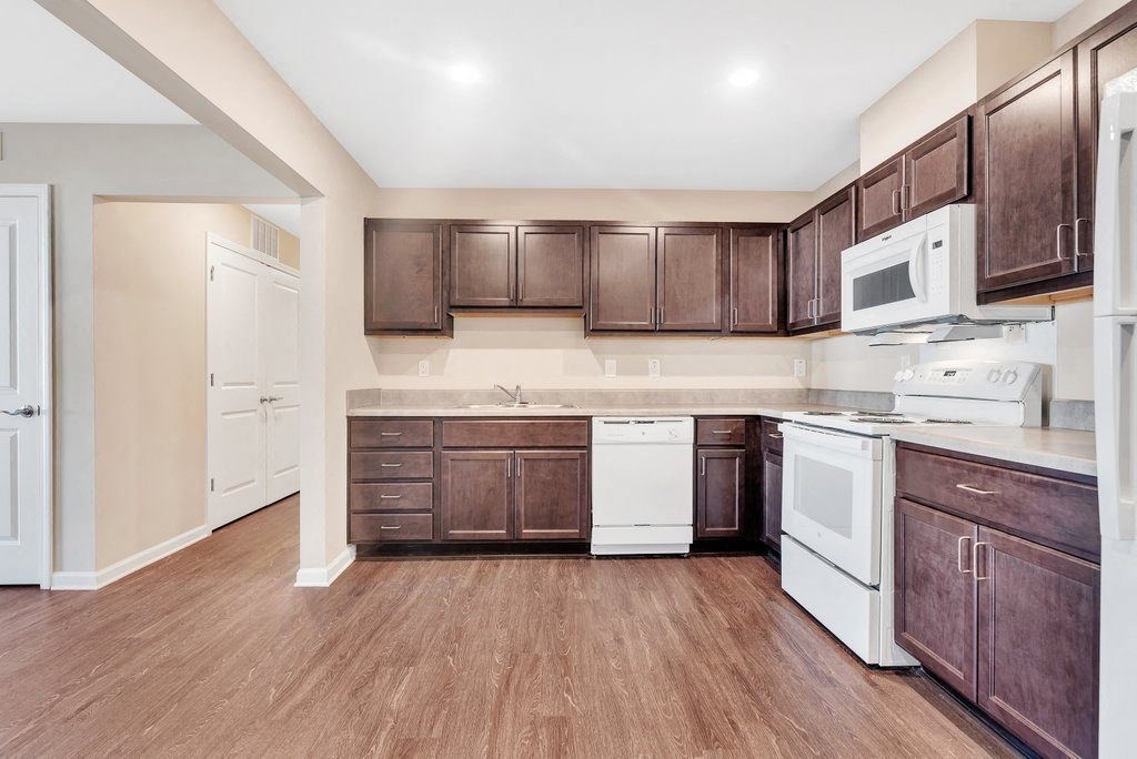 a kitchen with wooden cabinets and white appliances