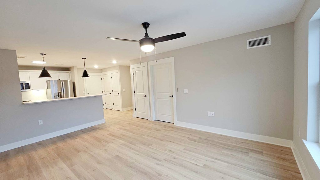 a living room and dining room with hardwood floors and a ceiling fan