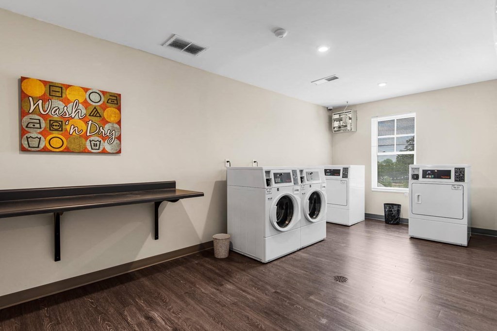 a laundry room with two washers and two dryers