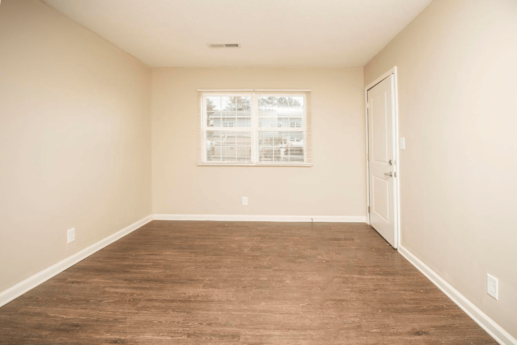 a empty room with a wood floor and a window