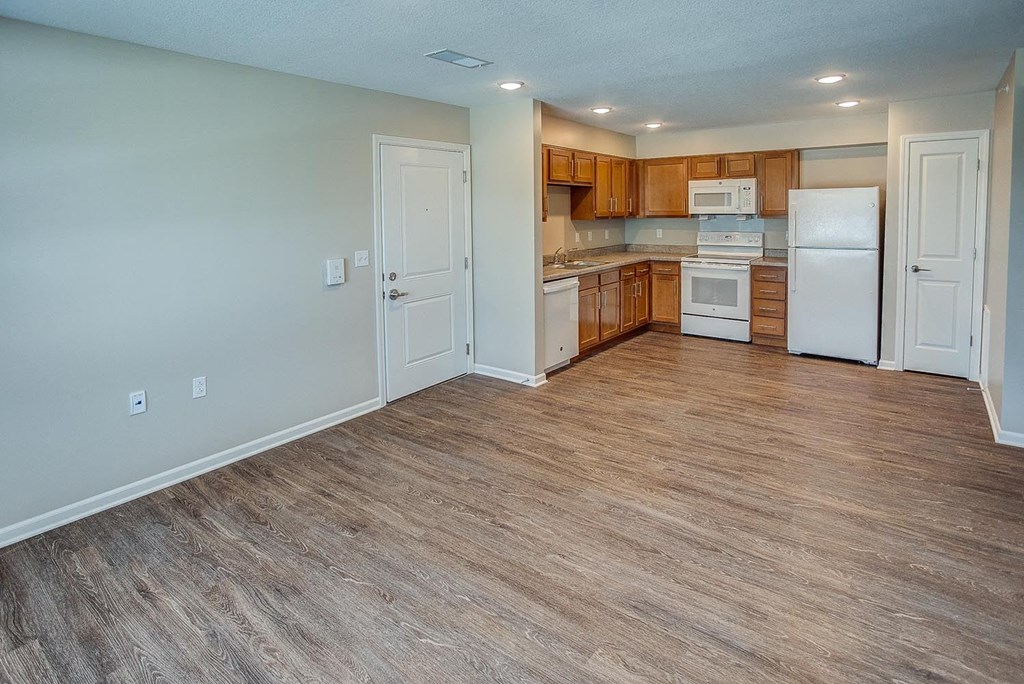 a kitchen with a wooden floor and a white refrigerator