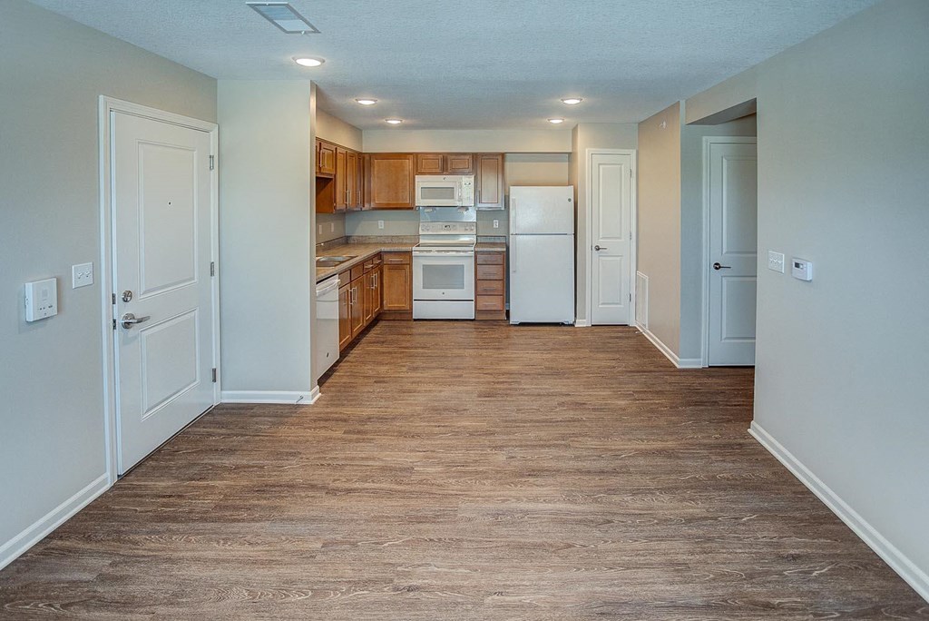 a renovated kitchen with a wood floor and white appliances