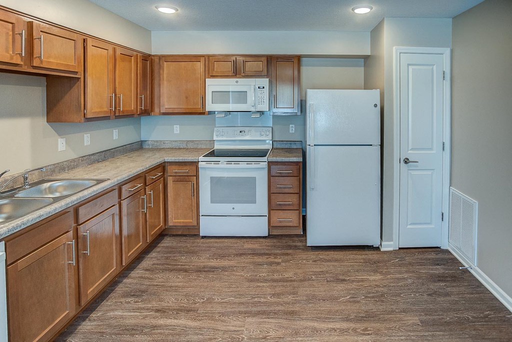 a kitchen with white appliances and wooden cabinets