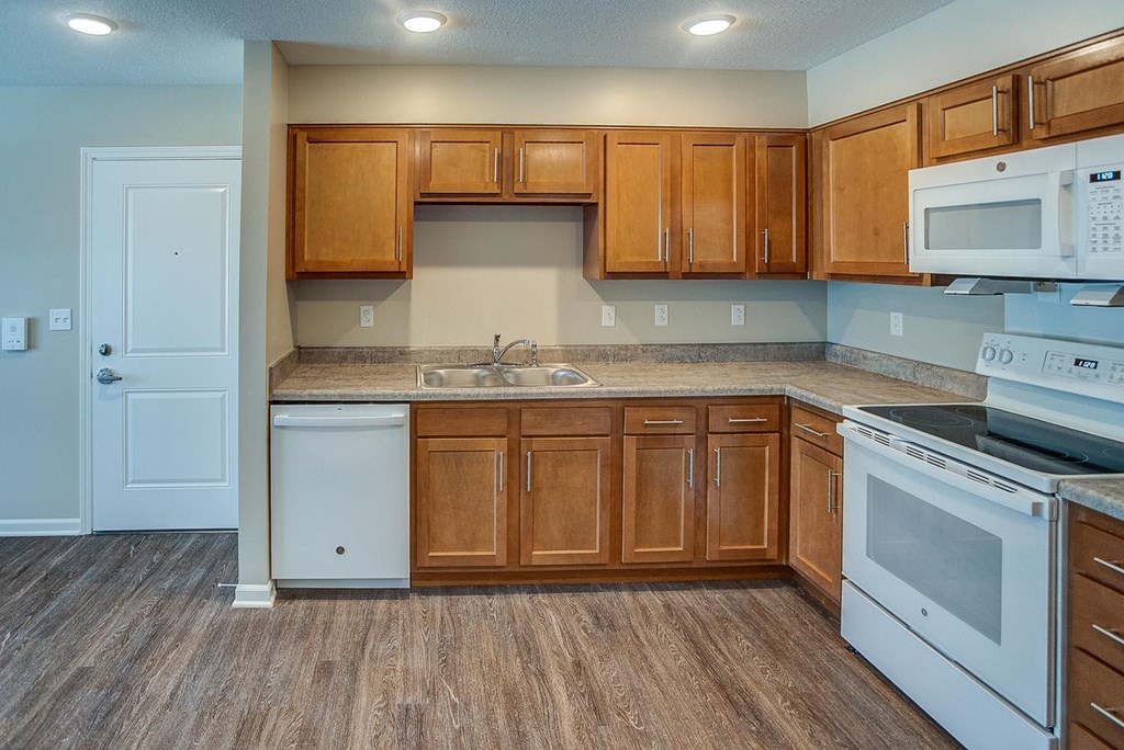a kitchen with white appliances and wooden cabinets