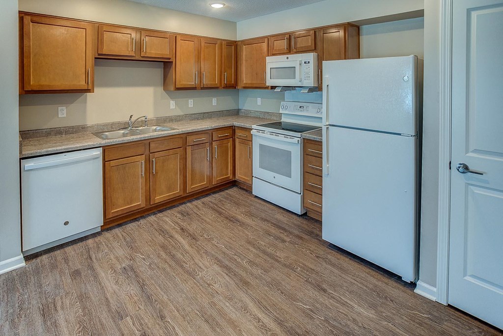a kitchen with white appliances and wooden cabinets
