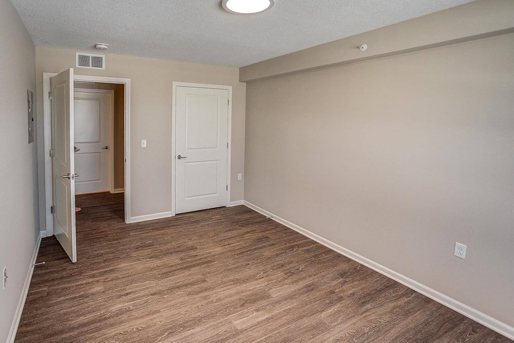 an empty living room with wood flooring and a white door