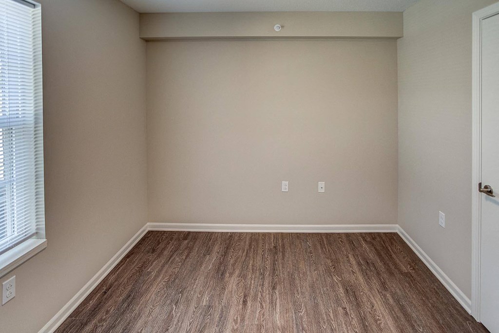 an empty room with wood floors and a window