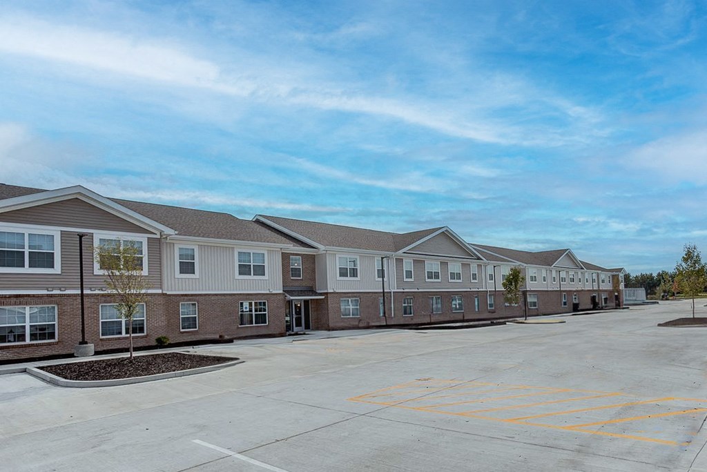 the parking lot in front of a row of brick apartment buildings