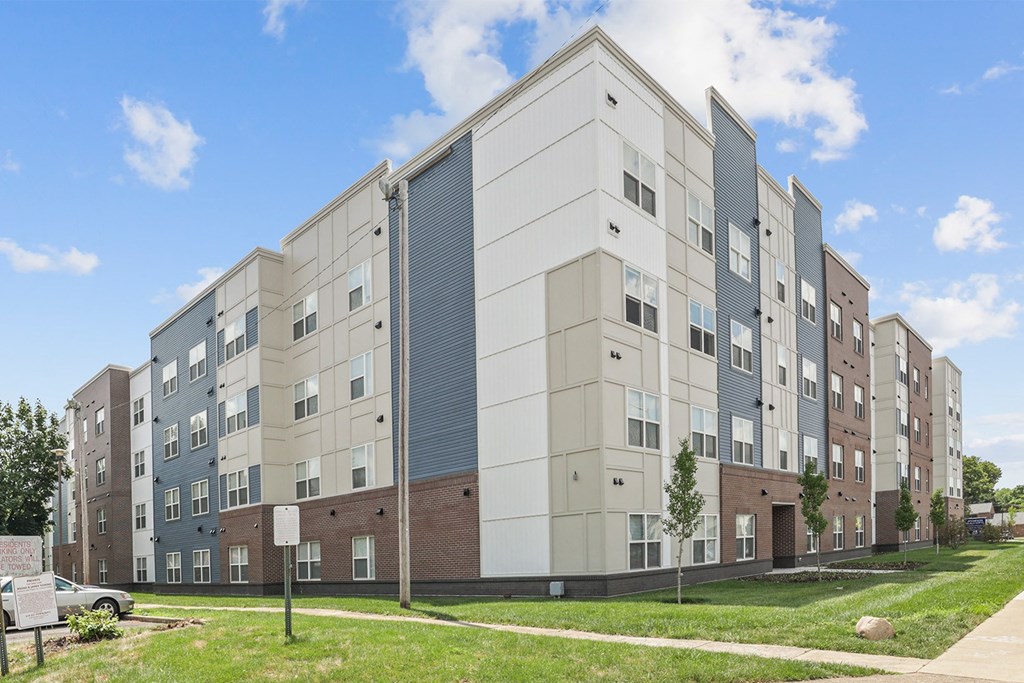 a large apartment building with a sidewalk in front of it