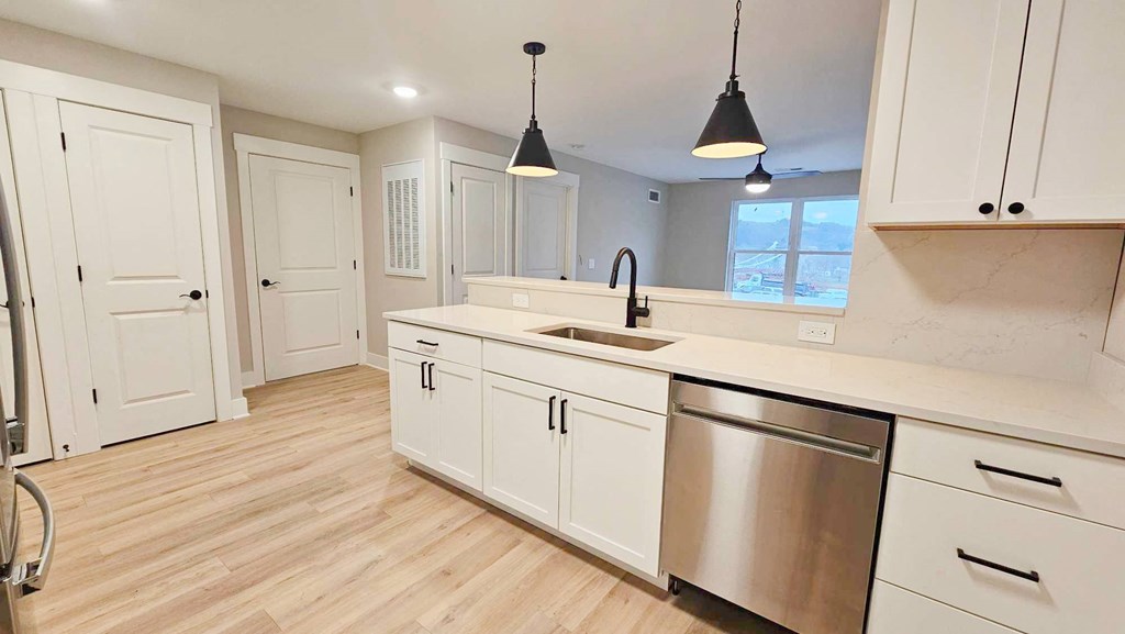 a kitchen with white cabinets and a stainless steel sink