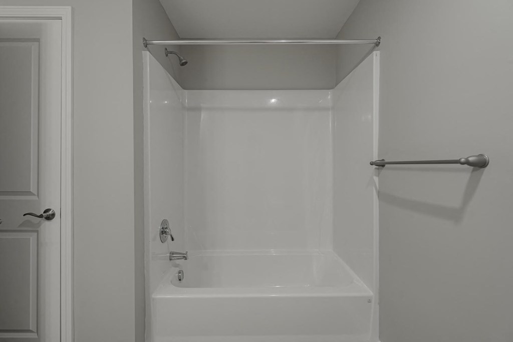 a white bathroom with a shower and a tub
