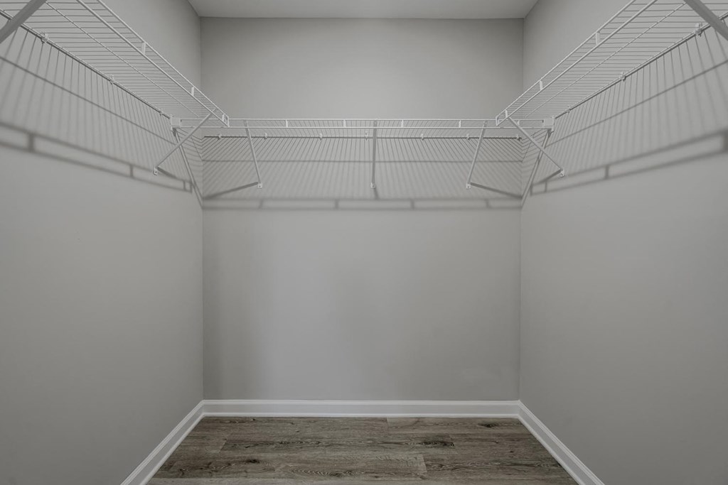 closet in a studio apartment with white walls and a wire closet rack