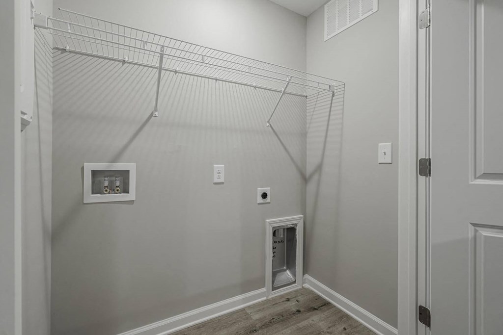 a walk in closet in a home with white walls and a door