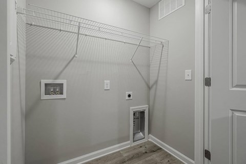 a walk in closet in a home with white walls and a door