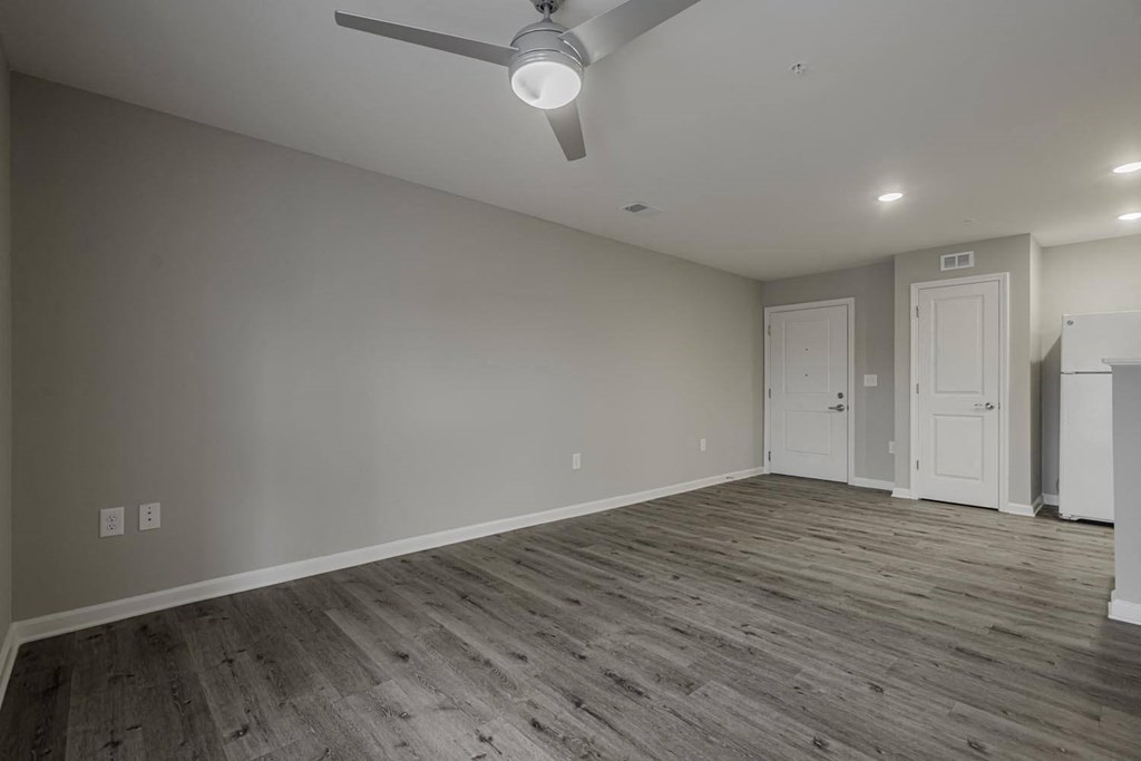 a living room with wood floors and a ceiling fan