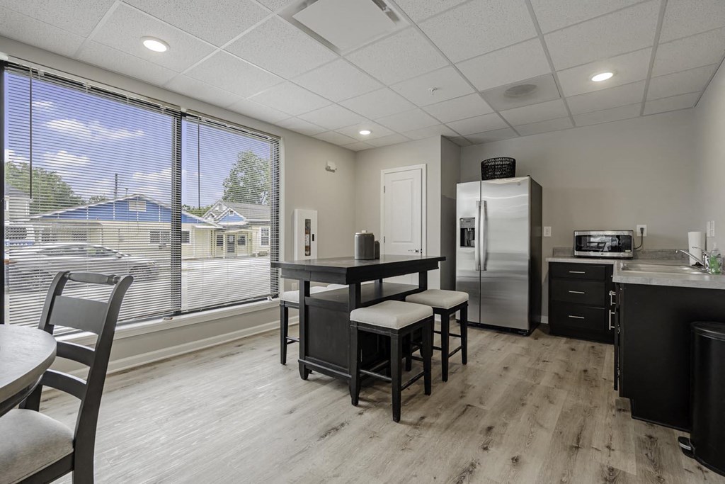 a kitchen with a table and chairs and a refrigerator