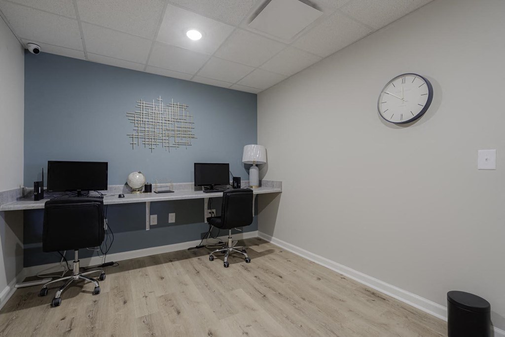 an office with two desks and a clock on the wall