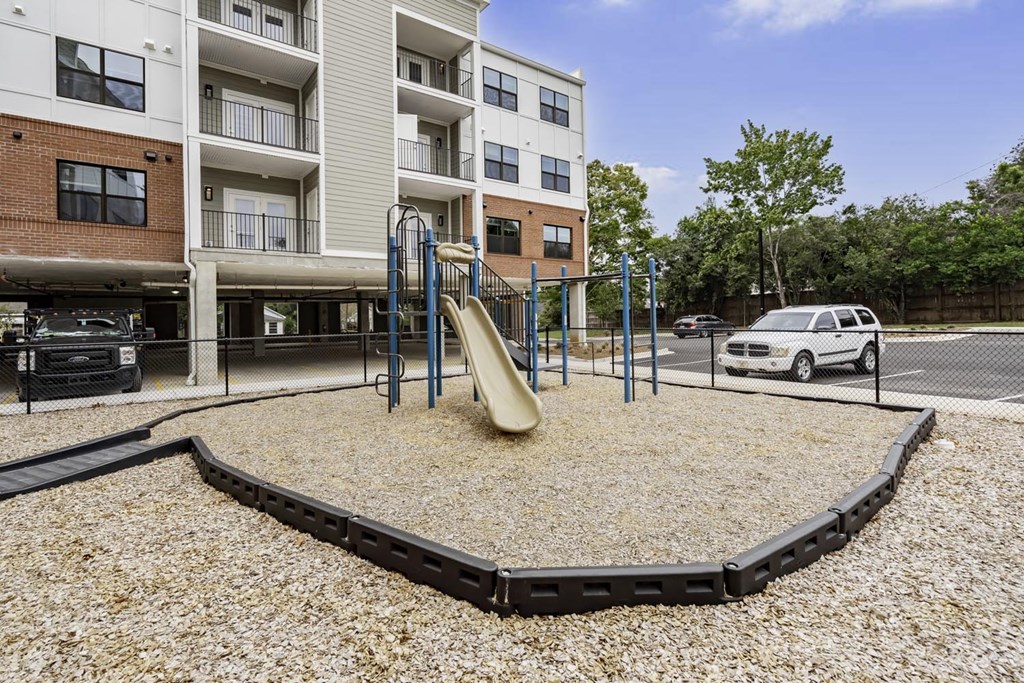 a playground at an apartment building with a slide