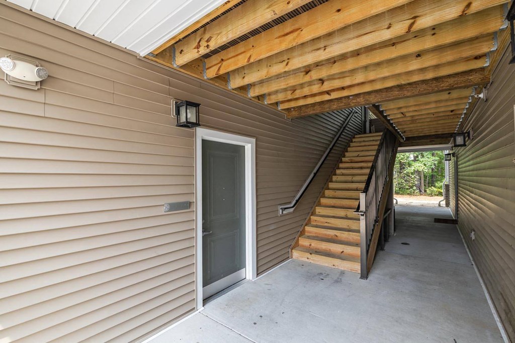 the front door of a home with stairs and a porch