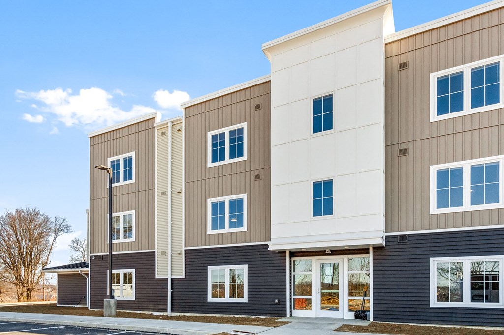 a row of buildings with brown and white facades and a sidewalk