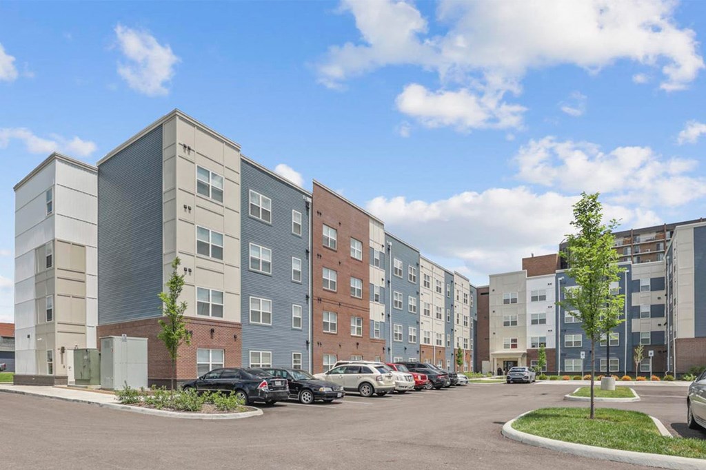 a rendering of an apartment building in a parking lot