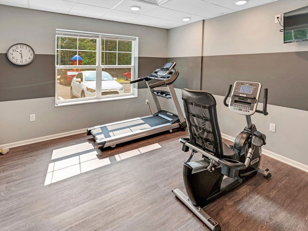 a home gym with a treadmill and a window