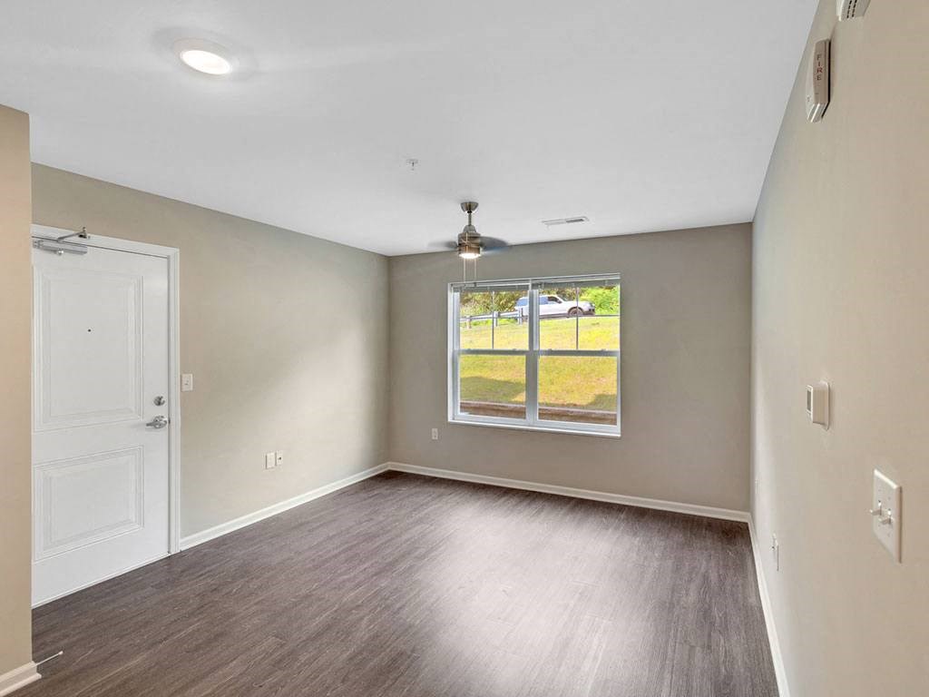 an empty living room with a window and a door