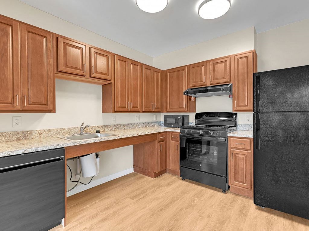 a kitchen with black appliances and wooden cabinets